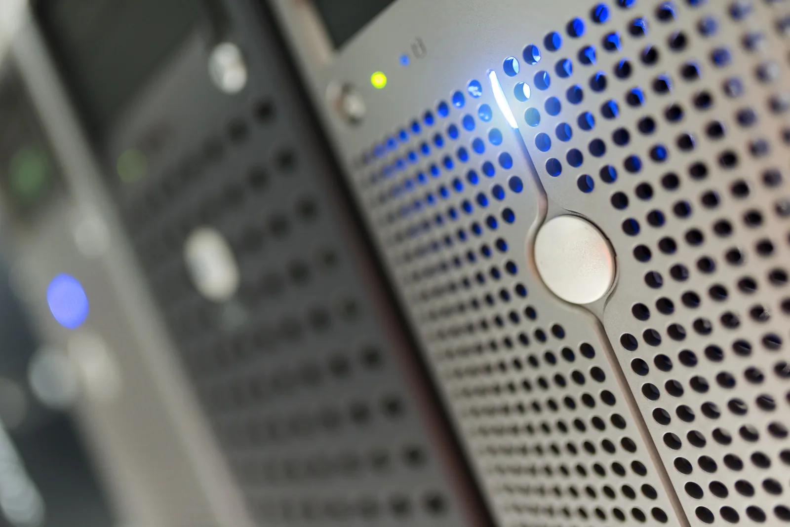 Close-up of perforated server panels with blue status lights.